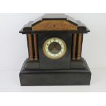 A late 19th century polished slate architectural mantel clock, enamelled chapter ring with Roman