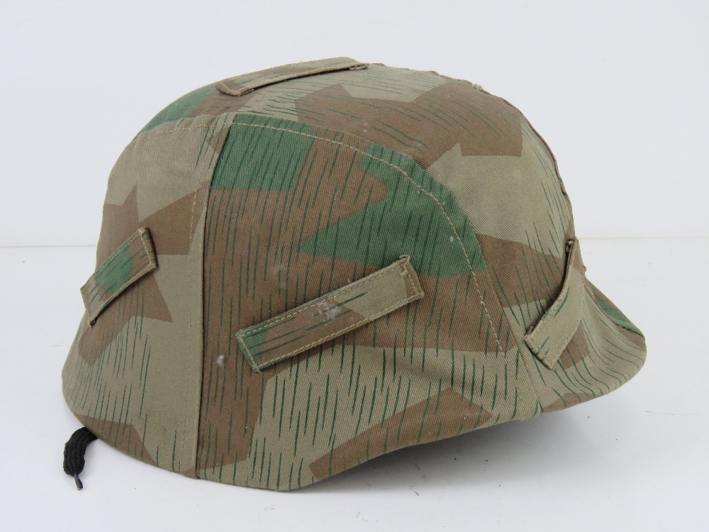 A reproduction M35 helmet with repro Splinter pattern Army helmet cover, liner and chin strap.