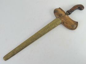 A Kris dagger with scabbard having a gilt gild blade, the hand carved handle set with stones.