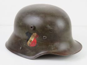 A reproduction M16 WWI/WWII German transitional Hitler Youth double decal camo helmet with liner.