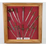 A collection of decorative miniature letter opener sized swords of historic themes, fifteen items.