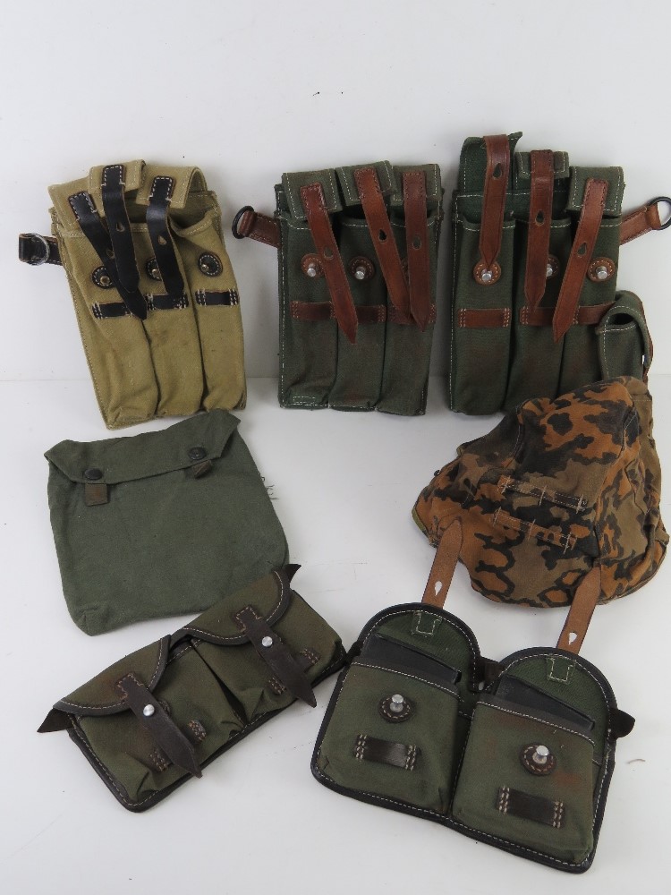 A quantity of assorted reproduction militaria; WWII German MP40 magazine pouches,