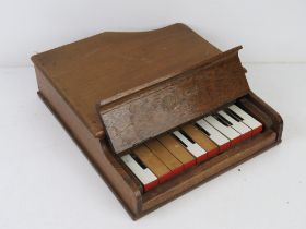 A Milton Grand miniature toy piano, legs deficient.
