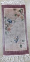 A prayer mat type rug decorated with birds and flowers measuring approx 63 x 30cm.