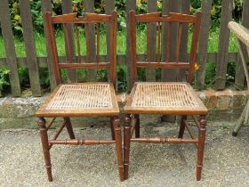 A matched pair of cane seated bedroom chairs having architectural pediment backs, ring turned legs.