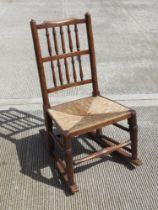 A spindle turned Lancashire style rush seated country made rocking chair.