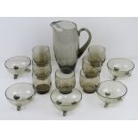A 1960s smoked glass breakfast set comprising jug, seven glasses and five bowls.