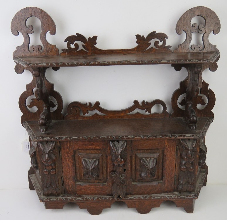 A 19thC carved oak wall hanging smoker's type cabinet.