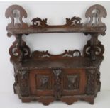 A 19thC carved oak wall hanging smoker's type cabinet.