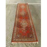 An orange ground Persian runner measuring 320 x 80cm.