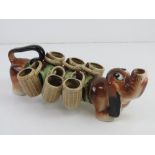 An unusual Japanese Brandy dog in the form of Daschund having six basket design cups upon,