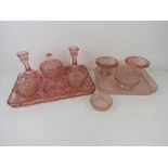Two early 20thC pink cut glass dressing table sets.