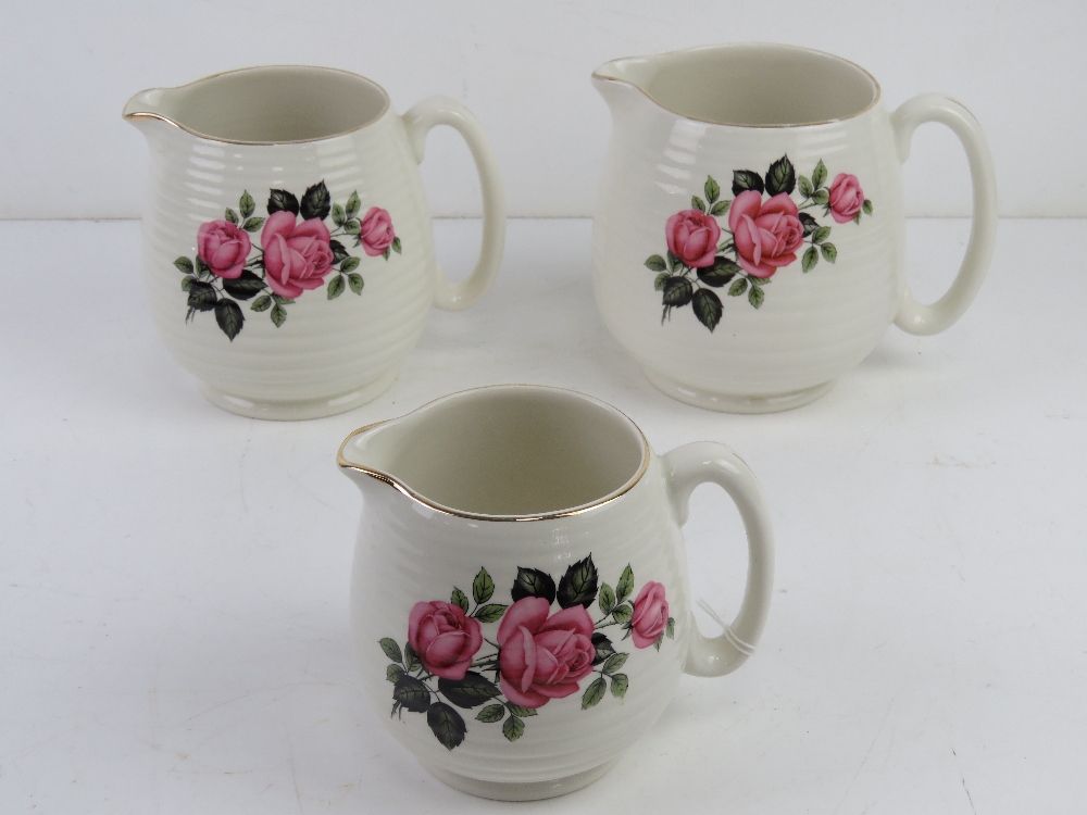A set of three graduated Beswick chintz creamware jugs having pink floral design upon.