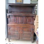 An 18th century oak court style cupboard having central field moulded panel to middle section and