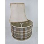 Two lampshades, one being cream silk, the other in tartan pattern.