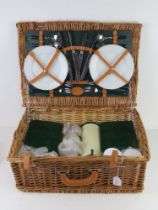 A wicker picnic basket for four by Marks & Spencer containing cutlery, plates, flask and tupperware,