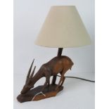 A carved wooden table lamp in the form of an African Gazelle type animal, slight a/f, with shade.