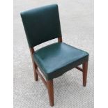 A single green leather office chair raised over mahogany frame.