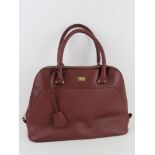 A burgundy leather handbag by Storm Lond