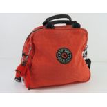 An orange canvas bag by Kipling with key