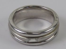 A hallmarked silver ring having baguette cut cz to central brushed finish band having polished