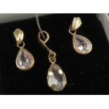 A suite of jewellery comprising earrings and pendant, white teardrop shaped stones,