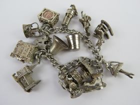 A HM silver charm bracelet with a quantity of large size charms upon including; miners lamp,