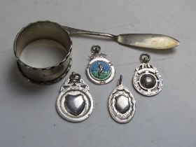 Four HM silver fob medals, one HM silver napkin ring and one HM silver butter knife.