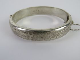A hallmarked silver hinged bangle having butterfly pattern upon, hallmarked for Birmingham,