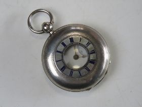 A HM silver half hunter pocket watch having blue enamelled external chaptering, white enamel dial,