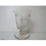 A single clear glass footed pouring cup having spout to one side, 15.5cm high.