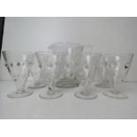 A clear glass lemonade set comprising six goblets and jugs.