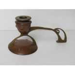 A single copper and brass candlestick of Art Nouveau design measuring approx 22cm wide.