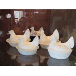 Four assorted opaque milk glass egg baskets in the form of chickens together with a blue and white