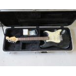 An electric guitar in a TGI case with tuner, etc.