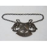 A HM silver sherry decanter label having pair of birds and triple barrel crest upon having banner