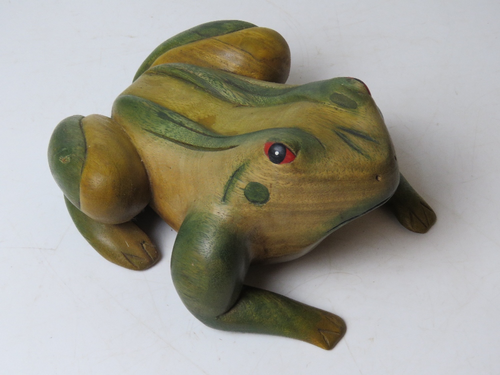 A carved and painted wooden doorstop in the form of a frog approx 27cm in length.