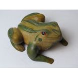 A carved and painted wooden doorstop in the form of a frog approx 27cm in length.