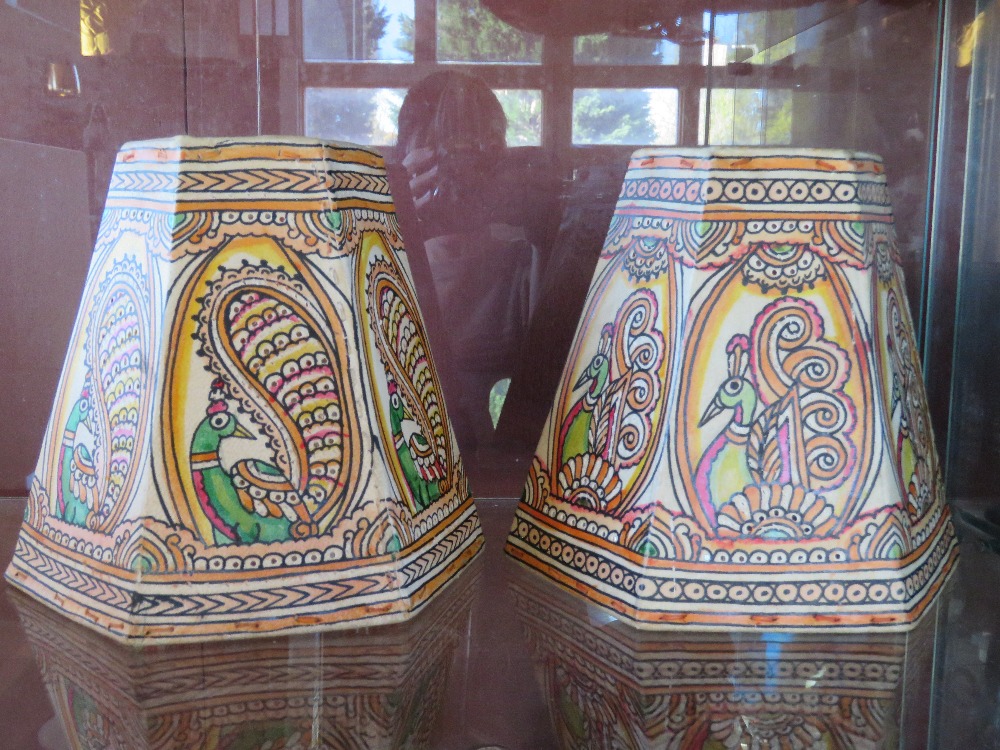 A pair of hand painted animal hide lamp shades, each 19cm high and decorated with peacock.