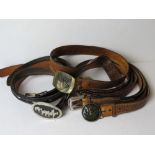 A quantity of assorted men's leather belts having various buckles upon, inc stag, ducks, etc,