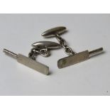 A pair of silver cufflinks having cricket bat design.