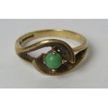 A 9ct gold ring having central green cabachon in wraparound setting, size O, 2.8g.