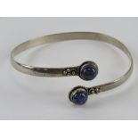 A lapis lazuli bangle, white metal stamped indistinctly.