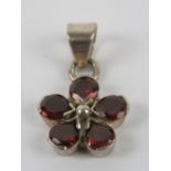 A silver floral cluster pendant, red coloured stones, stamped 925, 2.5cm inc bale.