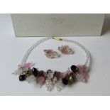 A floral contemporary beaded necklace with matching earrings in Daisy Chain of Cambridge England