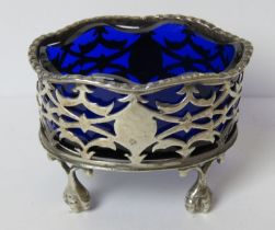 A HM silver salt raised over ball and claw feet with pierced design and blue glass liner, 6.