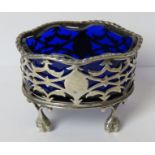 A HM silver salt raised over ball and claw feet with pierced design and blue glass liner, 6.