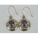 A pair of amethyst earrings, pierced scroll design, 4cm drop.