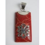 A silver mounted pendant in red with filigree design upon, stamped 925, 5.3cm inc bale.