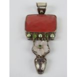 A large silver pendant having floral mother of pearl, green coloured pearl and faceted stones upon,